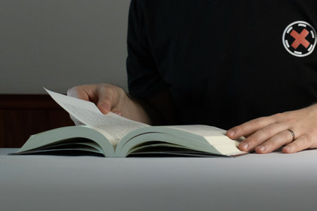 Caucasian man reading a book at nightの写真素材