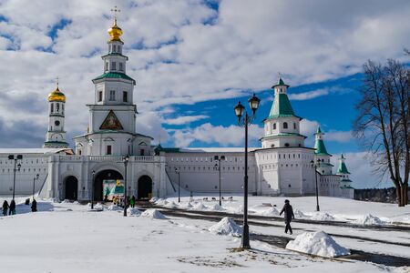Istra / Russia; March 27 2018: New Jerusalem monastery main entrance, with snow, white clouds and blue sky, people walking around, Istra, Russiaのeditorial素材