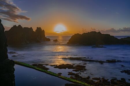 Sunset over the Atlantic ocean horizon, with volcanic rocks formation, long exposure, El Pris, Tacoronte, Tenerife, Canary islands, Spainの写真素材