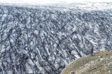 Vatnajokull glacier and lonely man taking photographの写真素材