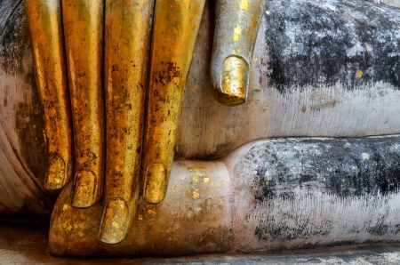 Beautiful golden hand of sitting Buddha in Wat Si Chum temple in Sukhothai, Thailandの写真素材