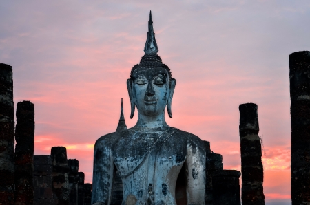 Detail of sitting Buddha at colorful sunset in Sukhothai historical park, Thailandの写真素材
