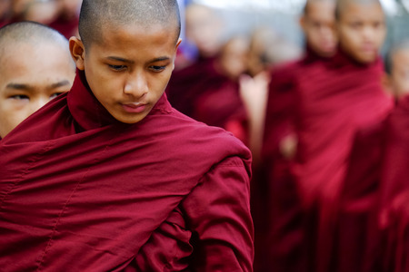 AMARAPURA, MYANMAR - JUNE 28, 2015: Buddhist monks queue for lunch in front of Mahagandayon monastery on 28 June 2015 in Amarapura.のeditorial素材