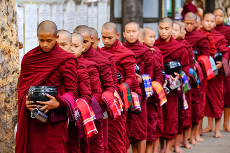 AMARAPURA, MYANMAR - JUNE 28, 2015: Buddhist monks queue for lunch in front of Mahagandayon monastery on 28 June 2015 in Amarapura.のeditorial素材