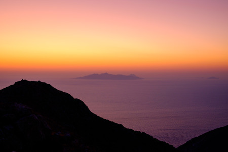 Landscape view of beautiful colorful sunrise above the ocean with horizon and distant islands, Santorini, Greeceの写真素材