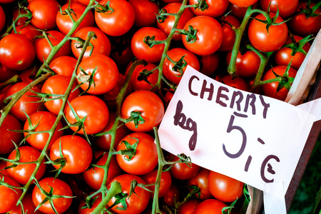 Close-up detail view of cherry tomatoes and price tag on the market