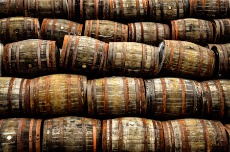 Stacked pile of old whisky and wine wooden barrels and casksの写真素材