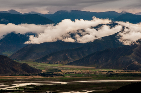 Dark moody landscape view of mountains and hills in Tibet, Asiaの写真素材