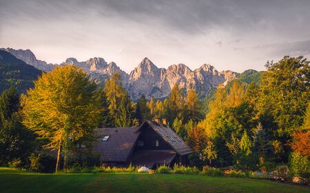 Landscape view of mountain peaks, colorful autumn foliage and cottage, Triglav national park, Slovenia, Europeの写真素材