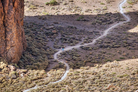 Trekking with child on a curvy path in desert landscapeの写真素材