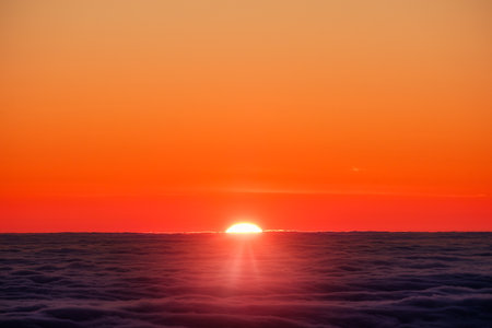 Scenic view of sun rising over clouds horizon, vivid colorful skylineの写真素材