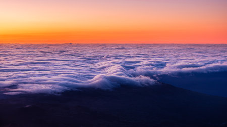 Beautiful colorful and vivid scenic view of sunrise over clouds and coastline, viewed from Mt Pico,...