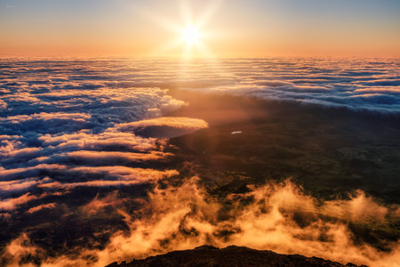 Colorful moody sunrise with clouds and volcanic rocks and steam foreground on Mt Pico, Azoresの写真素材