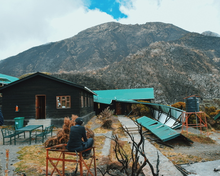 A hiker admiring the Saddle Hut in Mount Meru, Arusha National Park, Tanzaniaのeditorial素材