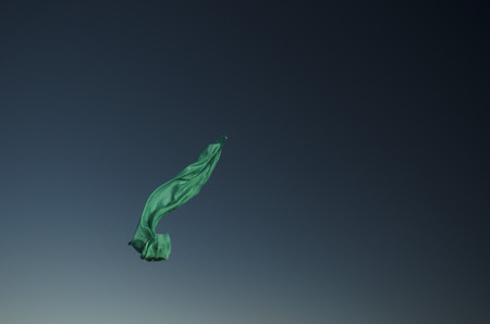 Green scarf flying in the sun with sky background