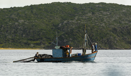 Group of coastal fishermen in their boat in search of preyの写真素材