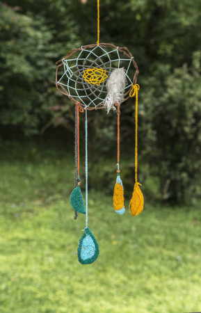 colorful handmade dreams catcher hanging in front of a background of forestの写真素材