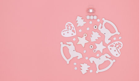 Christmas concept for greeting cards, white decorations collected in a christmas ball on a pink background, flat lay, top viewの写真素材