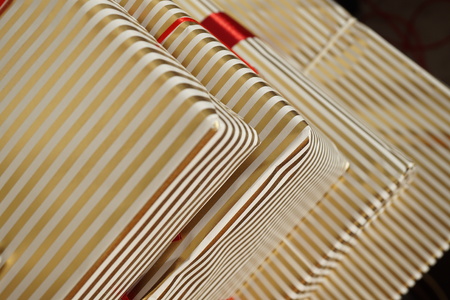Aerial view of edges of gift packages in white and golden lined wrapping paper as a background symbol of Christmas a Birthday giving and receivingの写真素材