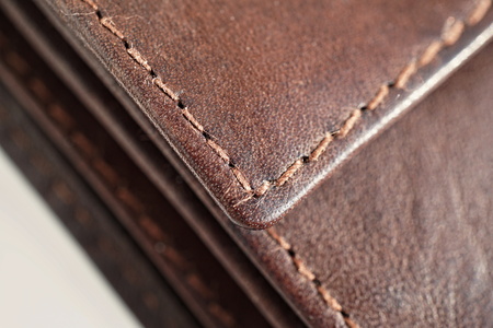Macro detail of a white and brown thread stitching black and brown stitched leather walletの写真素材