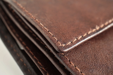 Macro detail of a white and brown thread stitching black and brown stitched leather walletの写真素材
