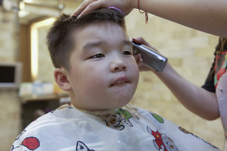 a 7 year old mixed race boy getting a hair cutの写真素材