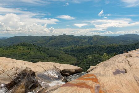 Sunny day in the Tropical waterfall falls from the mountain cliff to the jungle, serene landscape of Diyaluma falls.の写真素材