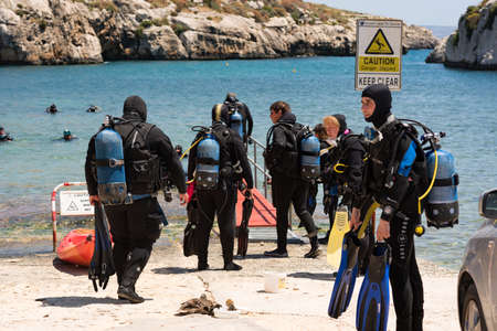 Mgarr Ix-Xini Bay, Malta : 2019 may 05: A group of divers comes out from Mediterranean sea near...