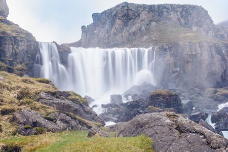 Waterfall in winter, Reyoarfjorour fjord, Iceland.