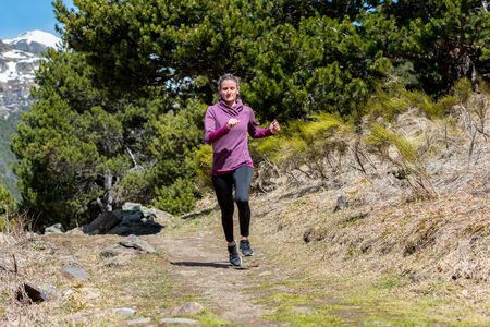 Young woman running up the hill. Trial run.