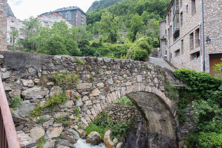 ESCALDES-ENGORDANY, ANDORRA - 2020 juny 8: River Madriu on La Tosca Bridge and houses view in a snowfall day in small town Escaldes-Engordany in Andorra on juny 2020.のeditorial素材