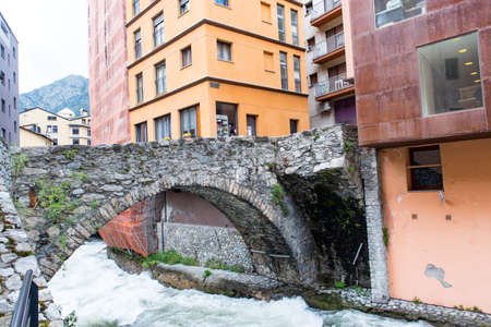 ESCALDES-ENGORDANY, ANDORRA - 2020 juny 8: River Valira on Engordany Bridge and houses view in a snowfall day in small town Escaldes-Engordany in Andorra on juny 2020.のeditorial素材