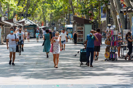 Barcelona, Spain - July 28 2020: People walking through empty streets after COVID 19 in Barcelona,...