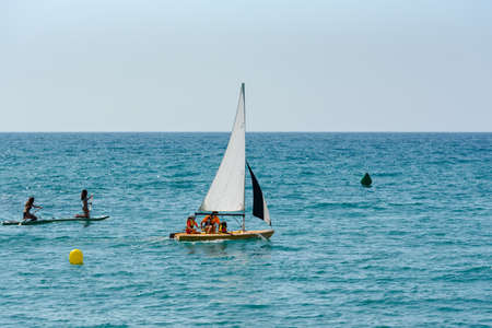 Sitges, Catalonia, Spain: July 28, 2020: Gay couple walking on the beach in Sitges in summer 2020.のeditorial素材