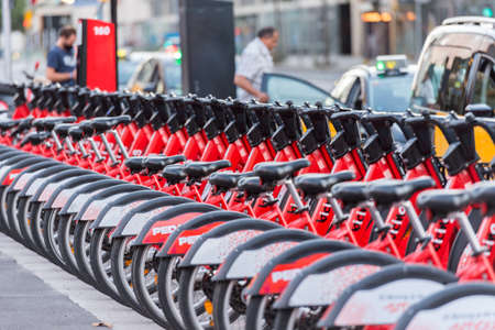 Barcelona, Spain - September 09, 2020: Bright red bicycles available for rent parked in a row at La Barceloneta. Concept of environmentally sustainable transport. Bike rental service Bicing.のeditorial素材