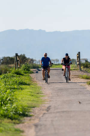Delta del Ebro, Spain: September 28: People cycling among the rice fields in the Delta del Ebro, Tarragona, Spain in summer 2020のeditorial素材