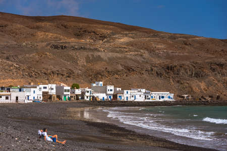 Pozo Negro, Fuerteventura, Spain; 2020 october 7: People walk in the beach of Pozo Negro on the...