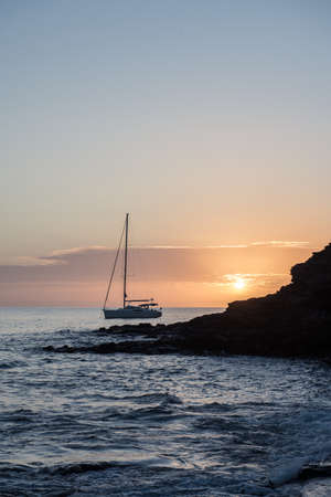 Boat at sunset in the Atlantic Sea on the Island of Fuerteventura in Spain.の写真素材