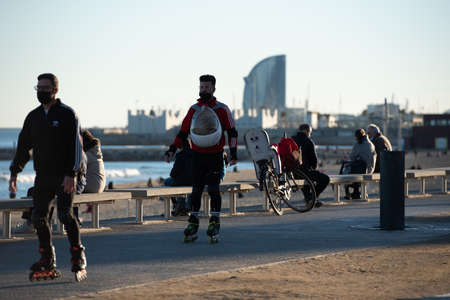 Barcelona, Spain: 2021 February 12: People walk along the Barcelona promenade in time of Covid 19 in winter 2021.のeditorial素材