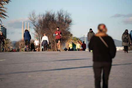 Barcelona, Spain: 2021 February 12: People walk along the Barcelona promenade in time of Covid 19 in winter 2021.のeditorial素材