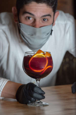 Bartender whit Sangria drink in glass isolated on a wooden table.の写真素材