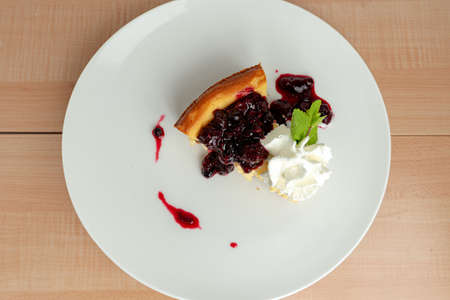 Cheesecake with blueberries from above on madrera background.