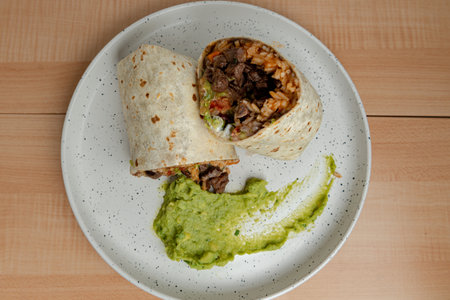 Classic Mexican Burrito dish on white plate.の写真素材