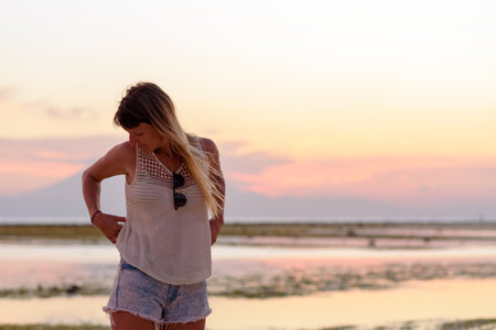Young blonde girl on Gili Trawangan beach in Lombik, Indonesia at sunset time.の写真素材