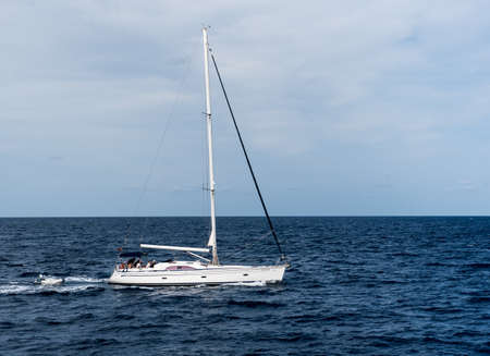 Formentera, Spain: 2021 august 2: Sailboat heading north on a sunny morning at Punta Prima on the...