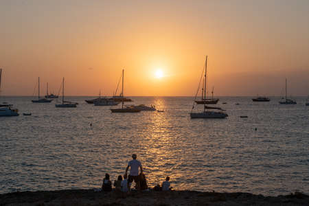 Formentera, Spain: 2021 August 18: People watching the sunset on the beach of Ses Illietes on the Island of Formentera in the summer of 2021.のeditorial素材