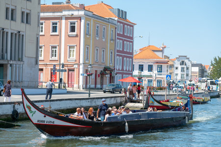 Aveiro, Portugal. 2022 May 12 . Traditional boats in the canal of Aveiro, Portugal. The colorful Moliceiro de Aveiro boat tours are popular with tourists to enjoy views of the charming canals. Aveiro, Portugal.のeditorial素材