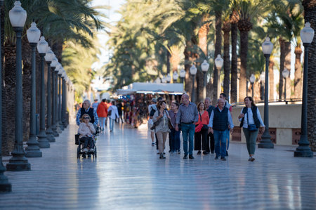 Alicante, Spain : 2022 November 18 : People walking on the Paseo Maritimo in the touristic city of...