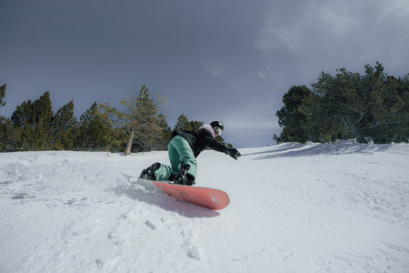 Snowboarder sliding down the hill in the mountains. Extreme winter sport.の写真素材