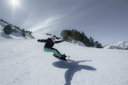 Snowboarder jumping in the air on a sunny winter day.の写真素材